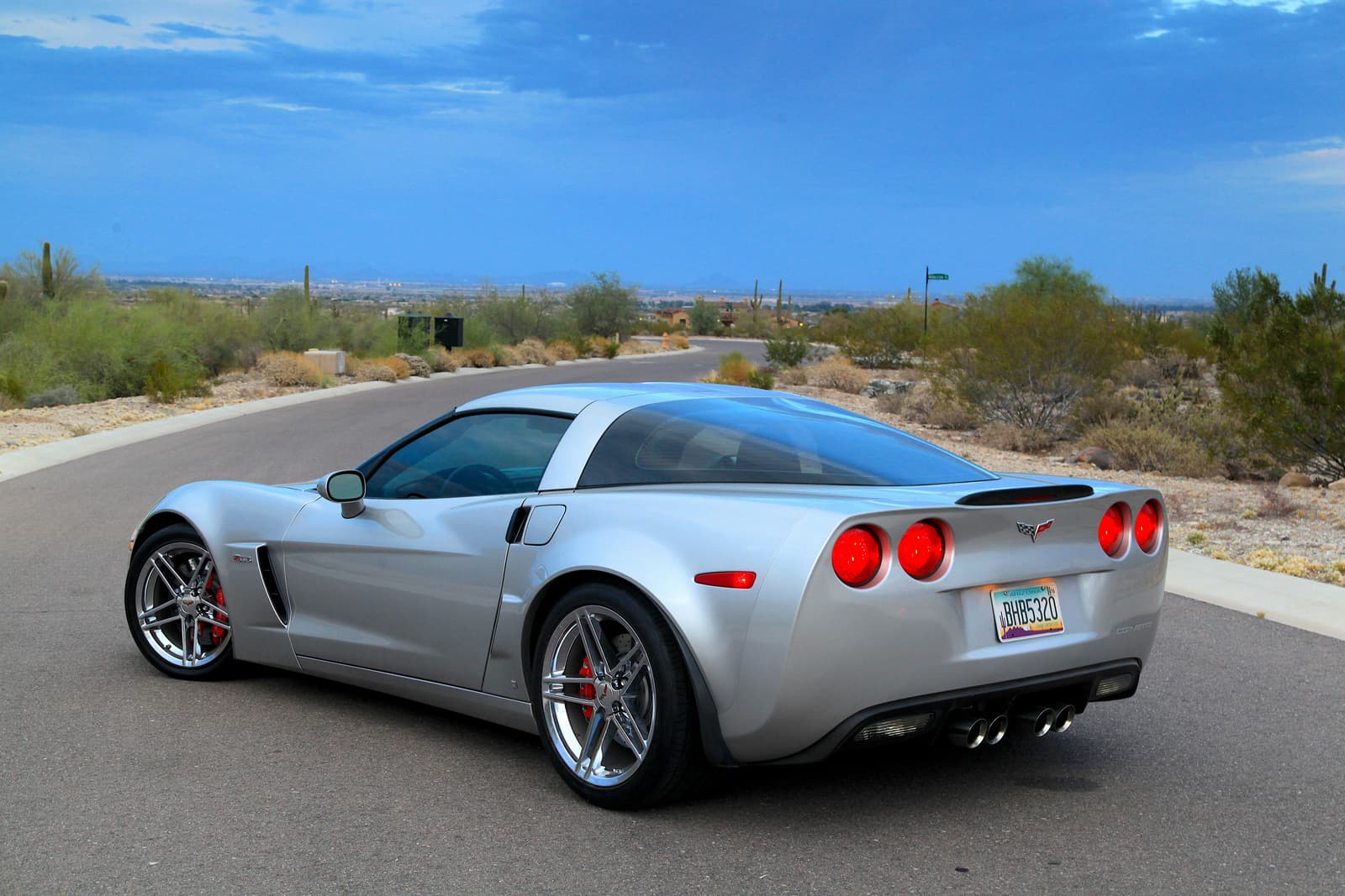 Silver Chevrolet Corvette sports car in a desert landscape