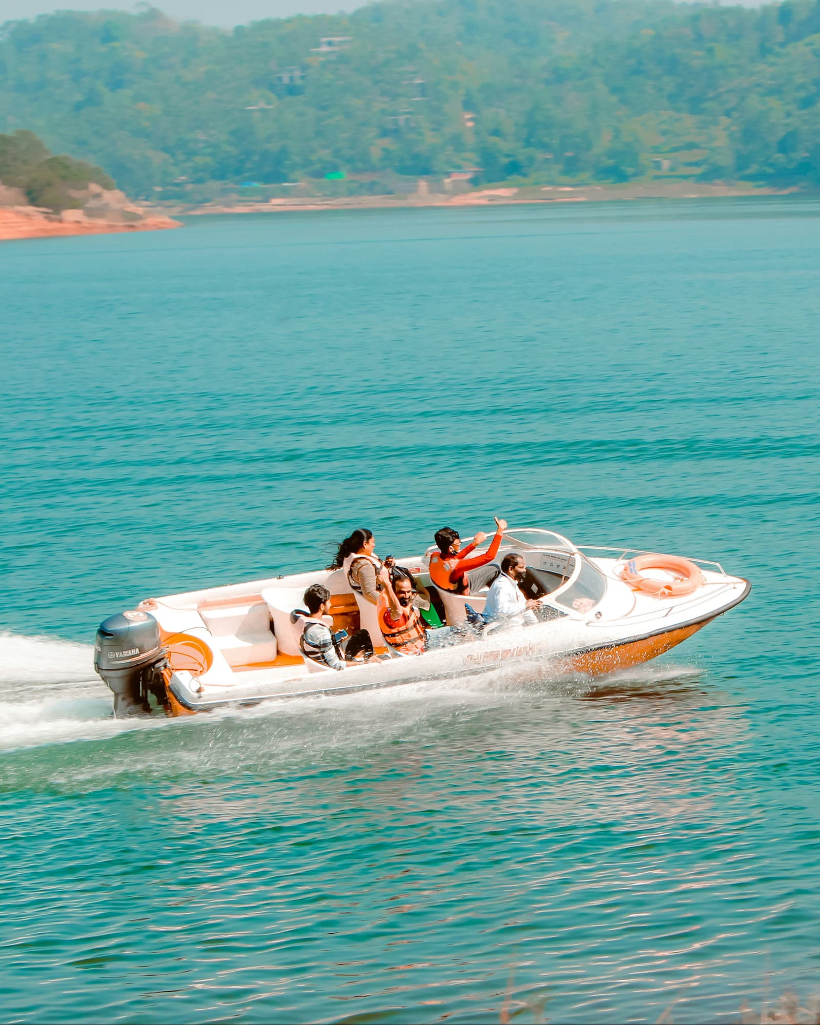 Speedboat with passengers cruising on turquoise lake water