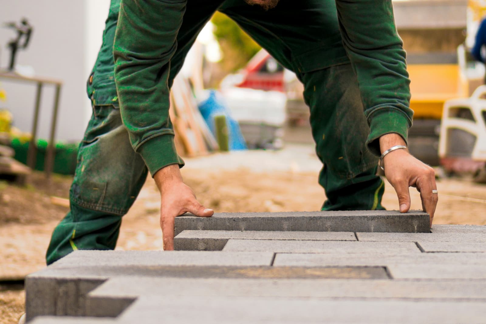 Worker laying paver bricks for a hardscape patio