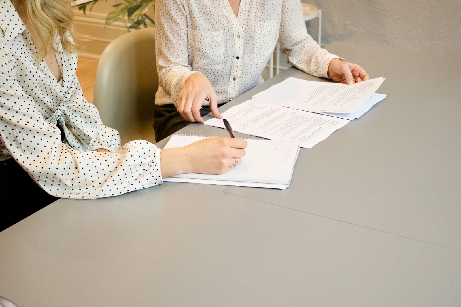 Two people reviewing and signing legal documents at a desk