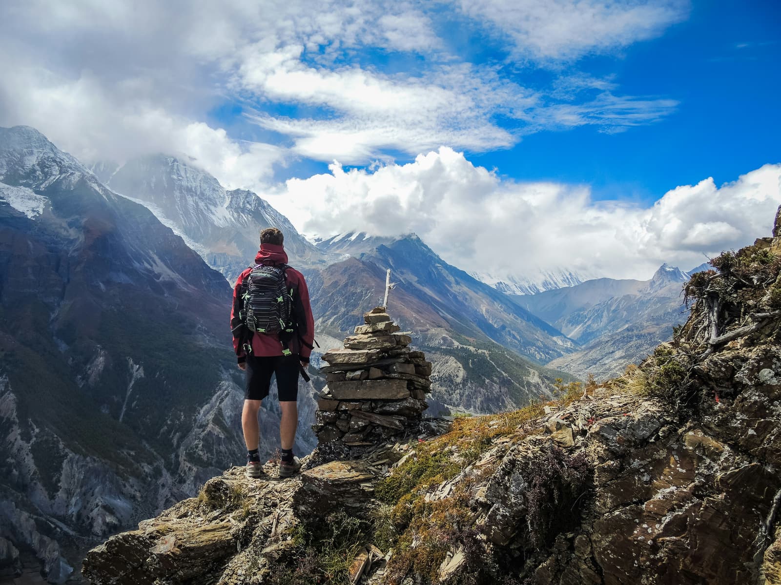 Hiker standing on mountain summit overlooking vast peaks